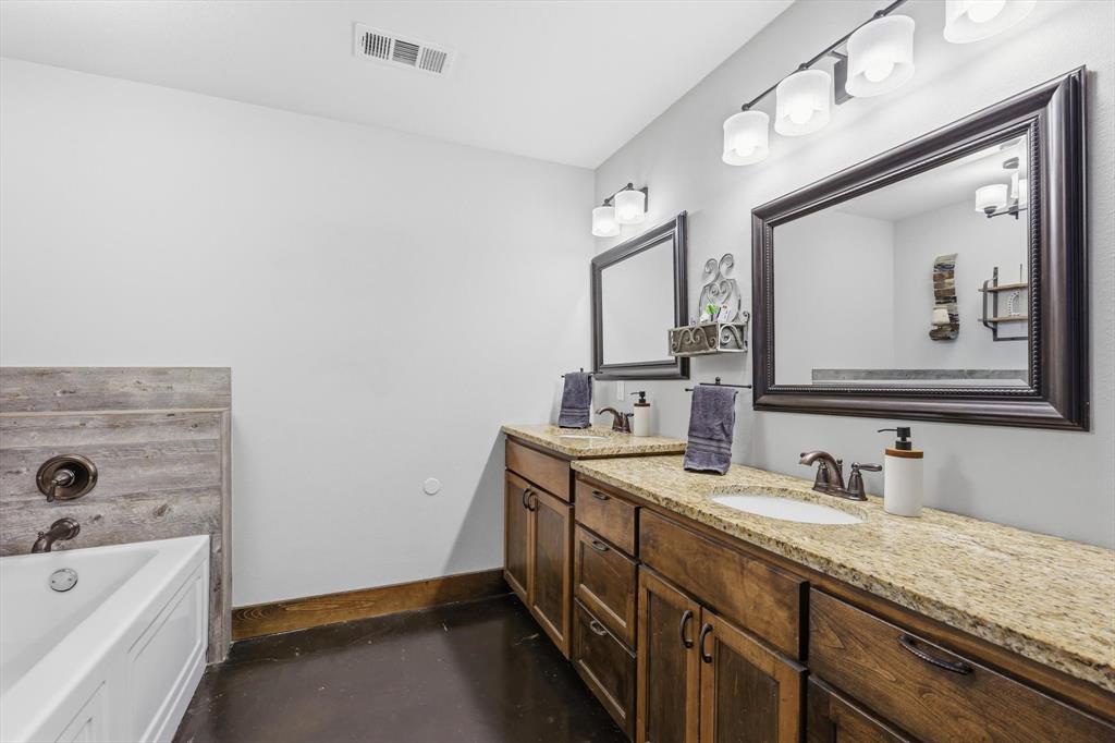 1748 Wilson Road Palmer, TX 75152 - Photo 12 of 40 a bathroom with a granite countertop double vanity sink and mirror with bathtub