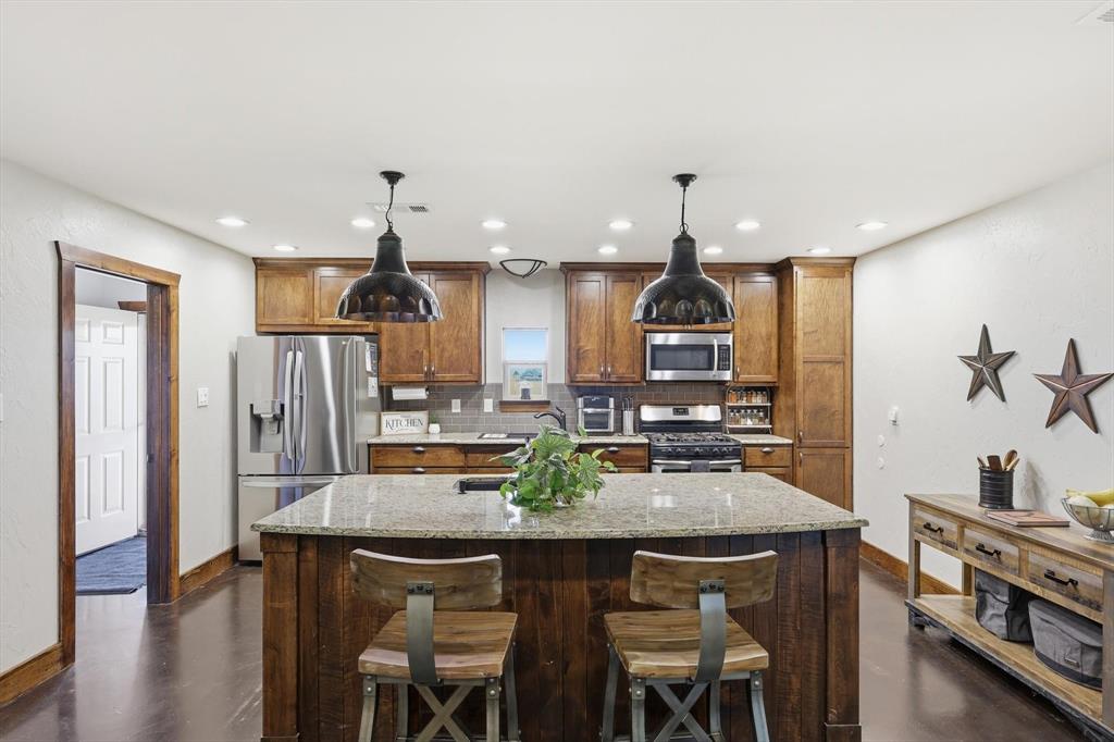 1748 Wilson Road Palmer, TX 75152 - Photo 4 of 40 a kitchen with stainless steel appliances a dining table chairs and wooden floor