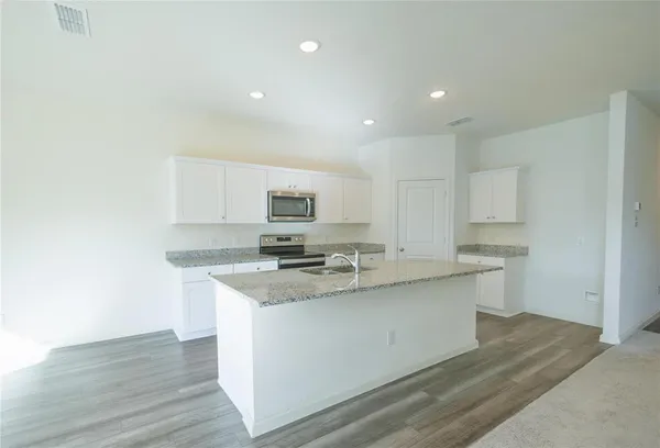 a kitchen with stainless steel appliances granite countertop a sink a stove and a refrigerator