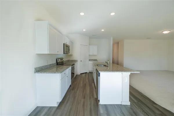 a kitchen with a sink a counter top space stainless steel appliances and cabinets