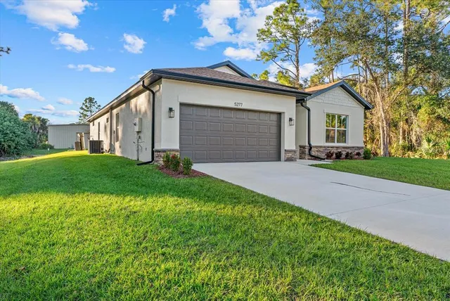 a front view of a house with a garden and yard