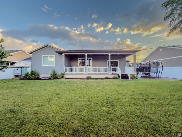 3269 West 650 North Layton, UT 84041 - Photo 29 of 35 Expansive backyard featuring a manicured lawn, a covered patio, and a white picket railing
