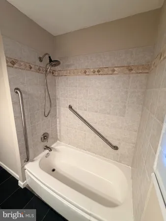a bathroom with a tub a sink and a shower