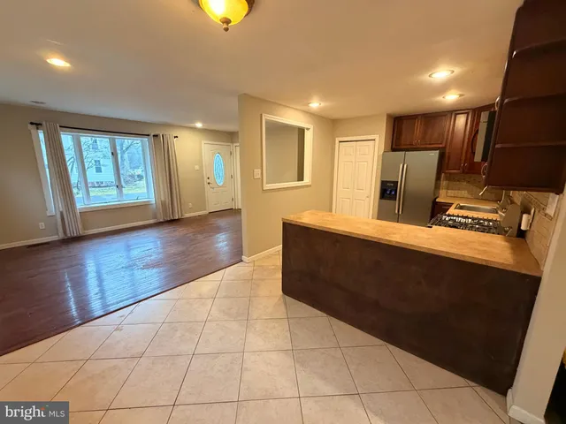 a living room with stainless steel appliances kitchen island granite countertop furniture a rug and a window