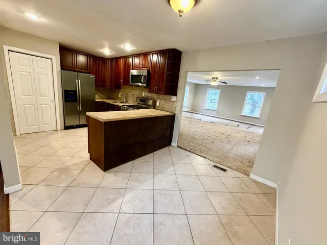 a view of kitchen with refrigerator and cabinets