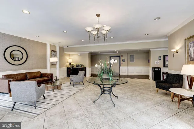 a living room with furniture a clock and a chandelier