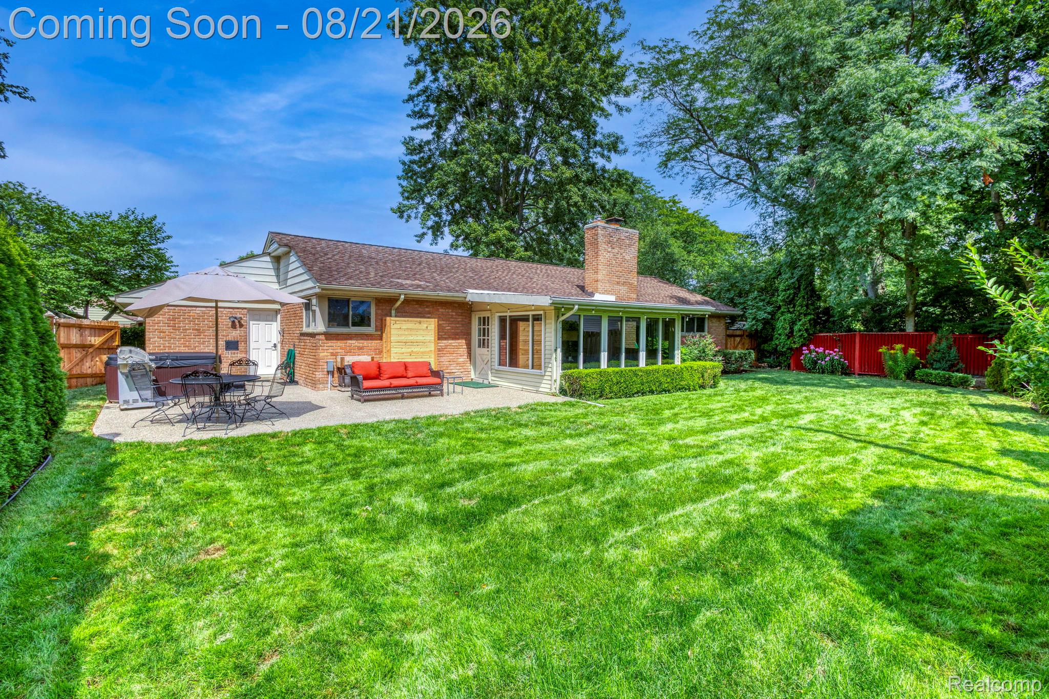 416 Barclay Road Grosse Pointe, MI 48236 - Photo 31 of 34 Expansive green lawn, brick exterior, large concrete patio, sunroom with multiple windows, and a prominent brick chimney