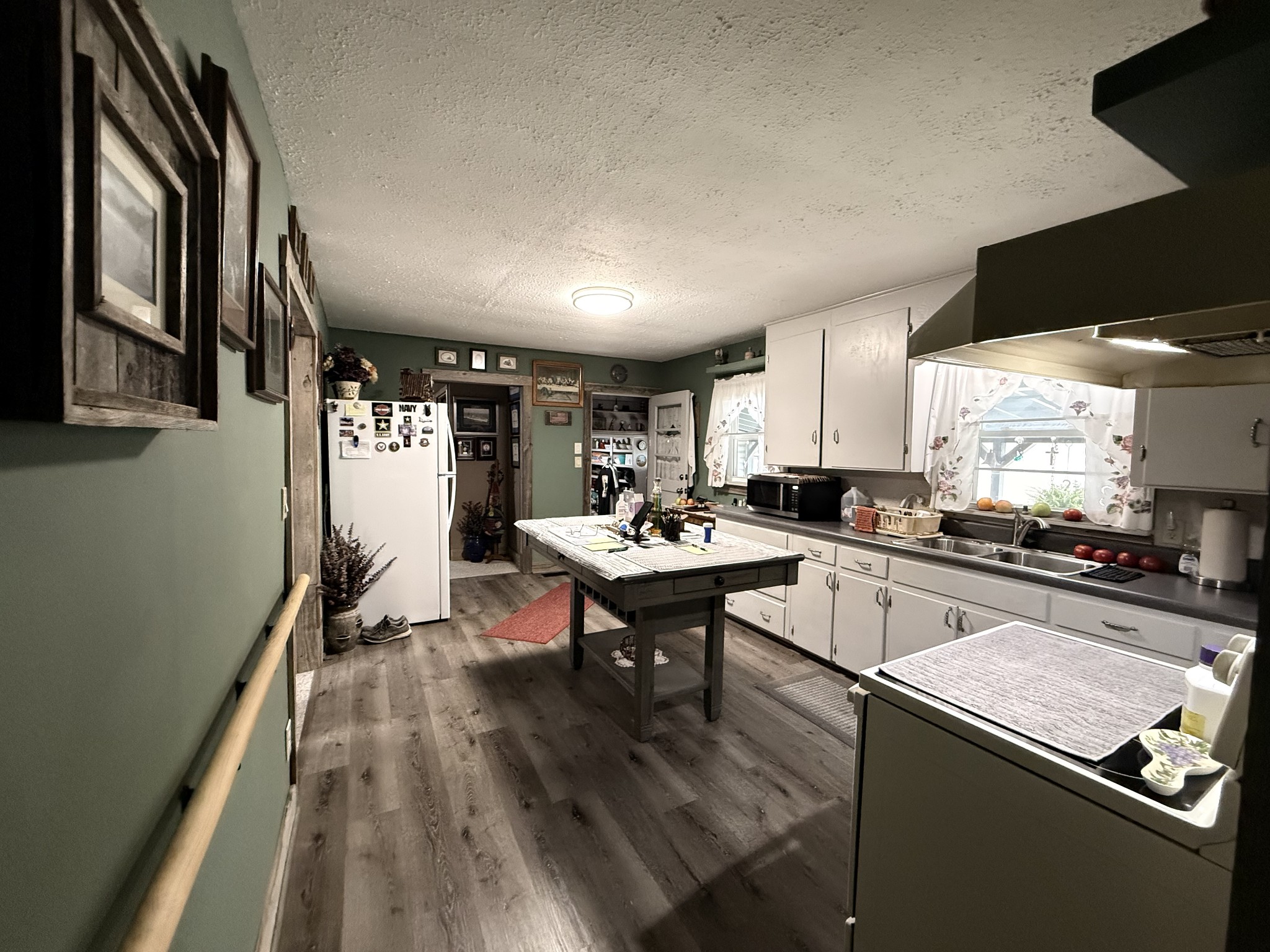 111 Gentry Street Tullahoma, TN 37388 - Photo 51 of 66 a kitchen with a sink dishwasher a stove and white cabinets with wooden floor