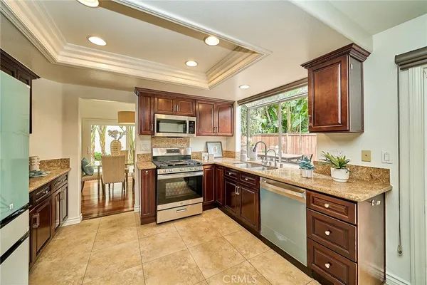 a kitchen with stainless steel appliances granite countertop a stove refrigerator sink and dishwasher