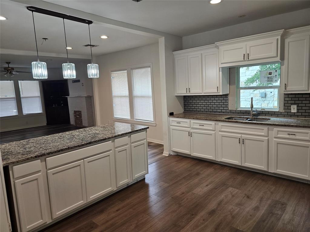 1704 Proctor Avenue Waco, TX 76708 - Photo 13 of 23 a kitchen with stainless steel appliances granite countertop a sink a stove and wooden floors