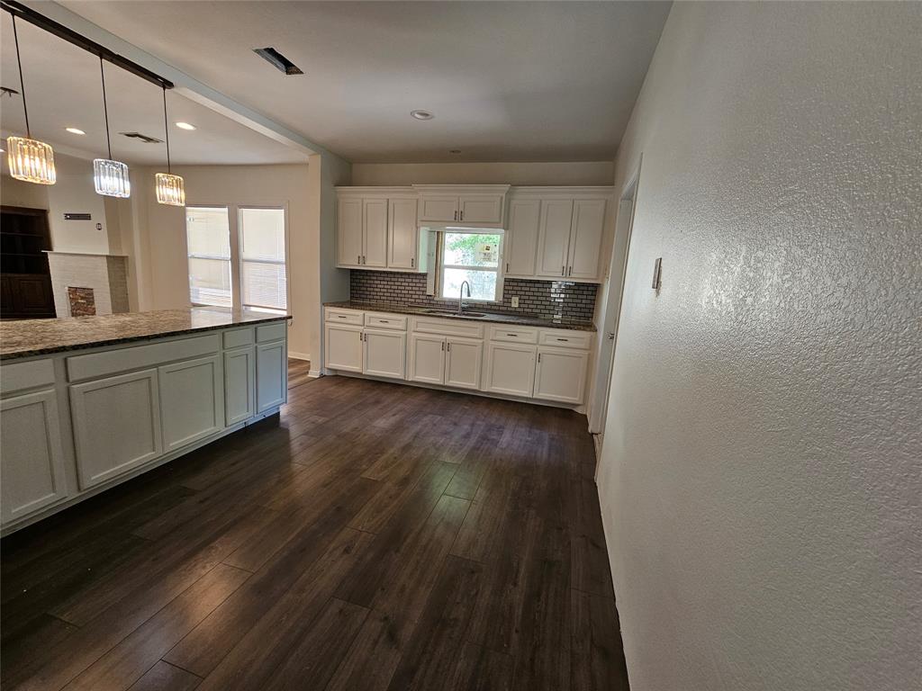 1704 Proctor Avenue Waco, TX 76708 - Photo 18 of 23 a kitchen with stainless steel appliances a refrigerator a sink dishwasher a stove and white countertops with wooden floor