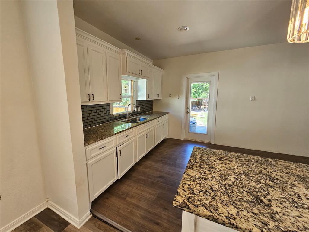1704 Proctor Avenue Waco, TX 76708 - Photo 9 of 23 a kitchen with granite countertop white cabinets and window