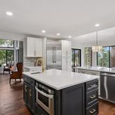 a kitchen that has a lot of cabinets a sink and wooden floor