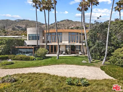 a front view of a house with a garden and yard