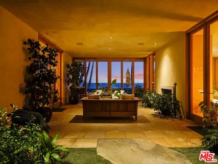 a living room with furniture potted plant and a large window