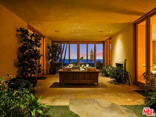 a living room with furniture potted plant and a large window
