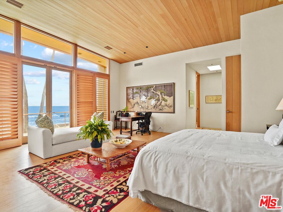 31280 Broad Beach Road Malibu, CA 90265 - Photo 27 of 43 a bed room with a bed and glass table chair