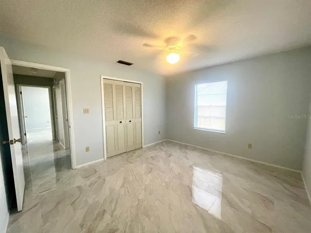 a bathroom with a granite countertop sink a toilet a mirror and bathtub
