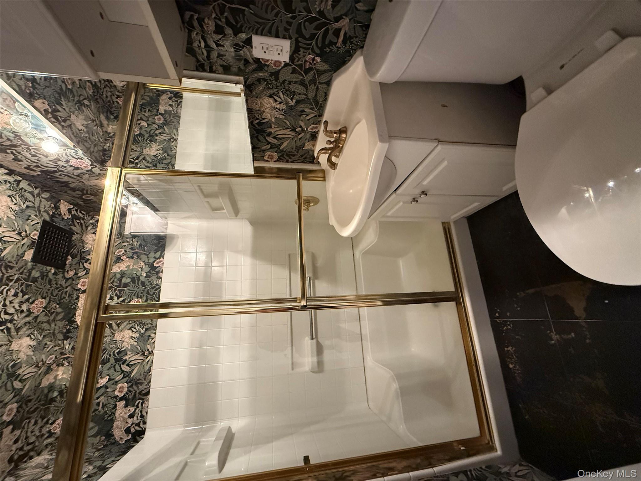 15 Canterbury Road, Unit D13 Great Neck, NY 11021 - Photo 3 of 10 Bathroom featuring wallpapered walls, vanity, and a stall shower