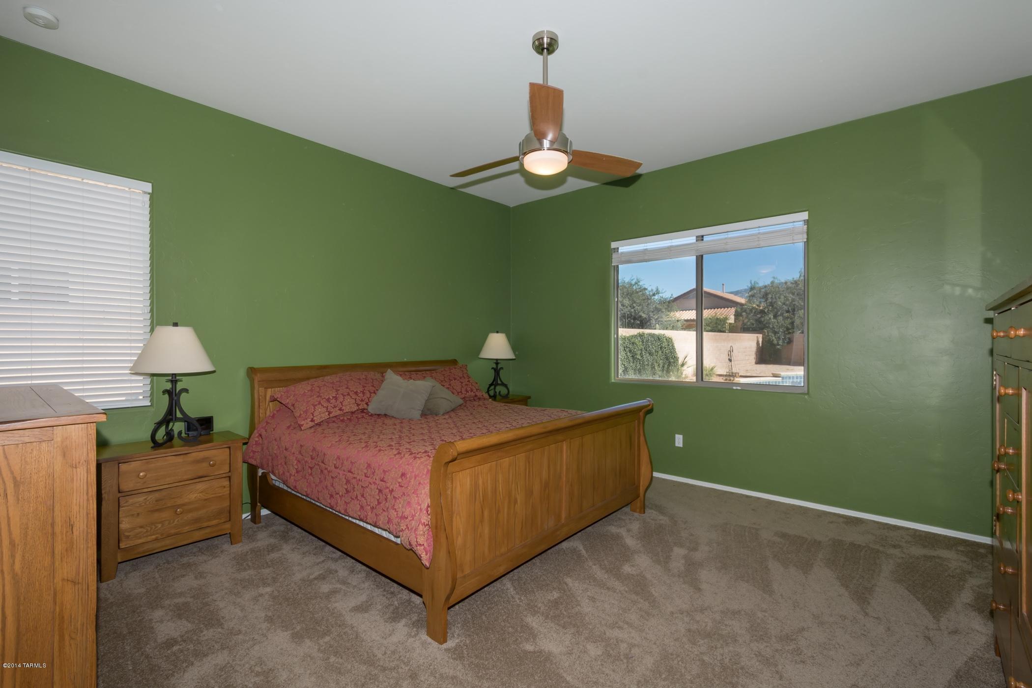 15082 North Holsteiner Road Tucson, AZ 85739 - Photo 22 of 34 a bedroom with a bed and a chandelier