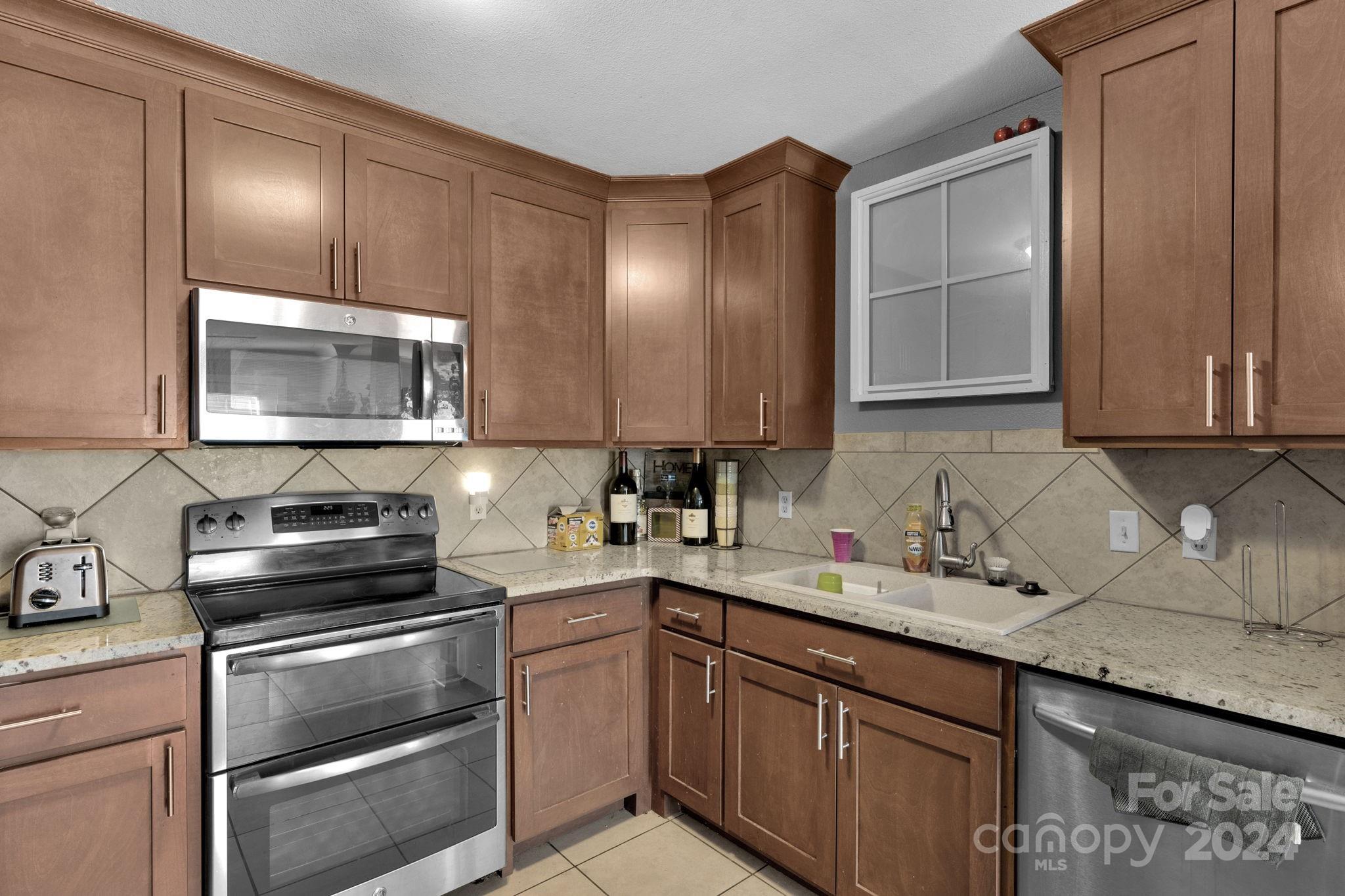 738 Sinclair Drive Monroe, NC 28112 - Photo 13 of 33 a kitchen with stainless steel appliances granite countertop a sink stove and microwave