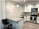 3120 Seasons Way, Unit 309 Estero, FL 33928 - Photo 7 of 33 a kitchen with kitchen island granite countertop a sink and a stove top oven