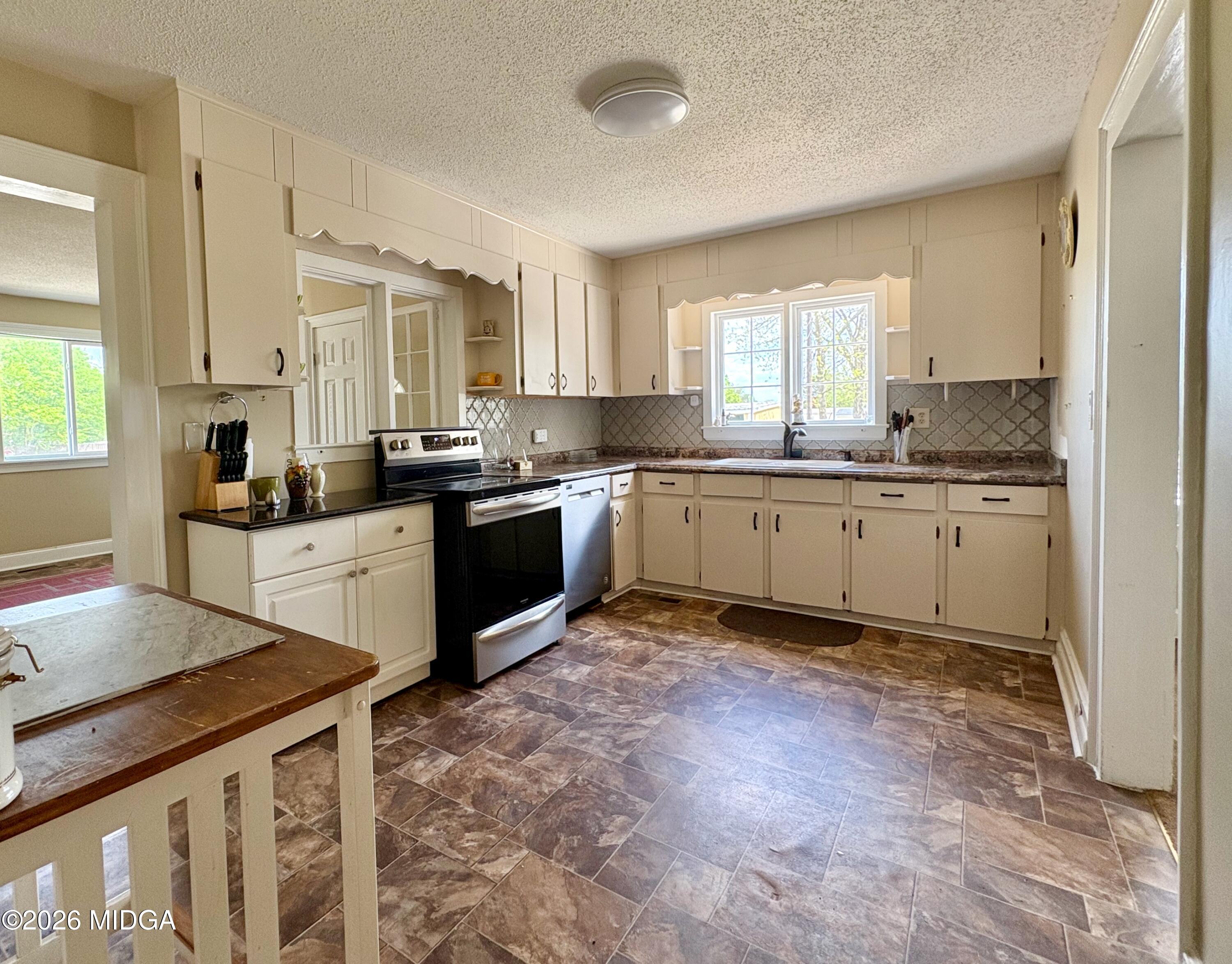 205 White Road Byron, GA 31008 - Photo 8 of 38 a kitchen with granite countertop sink stove and cabinets