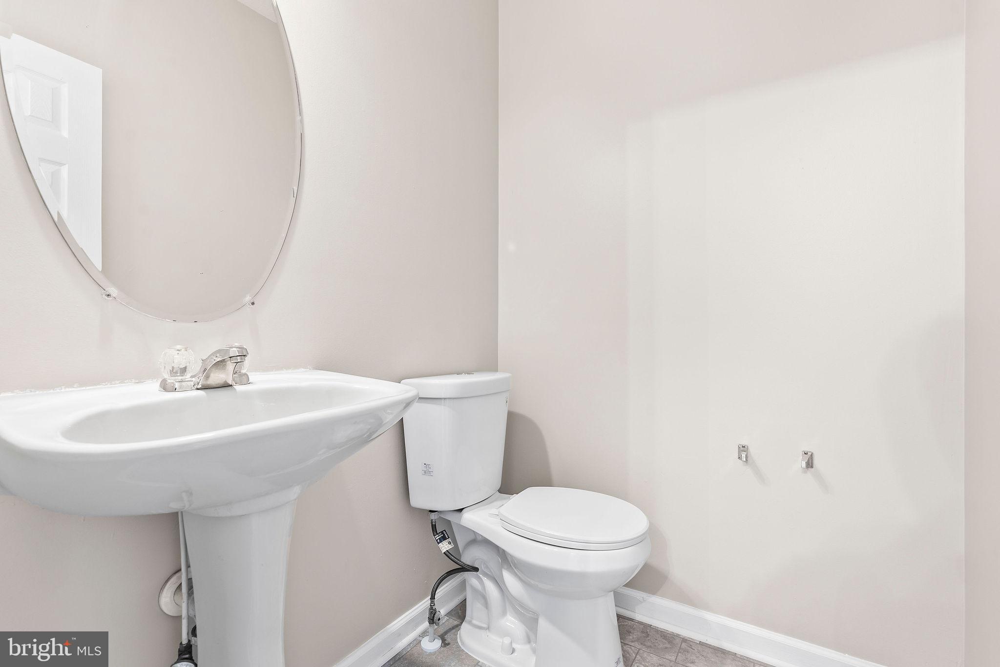 9711 Luguna Road Baltimore, MD 21220 - Photo 14 of 37 a bathroom with a sink a toilet and mirror