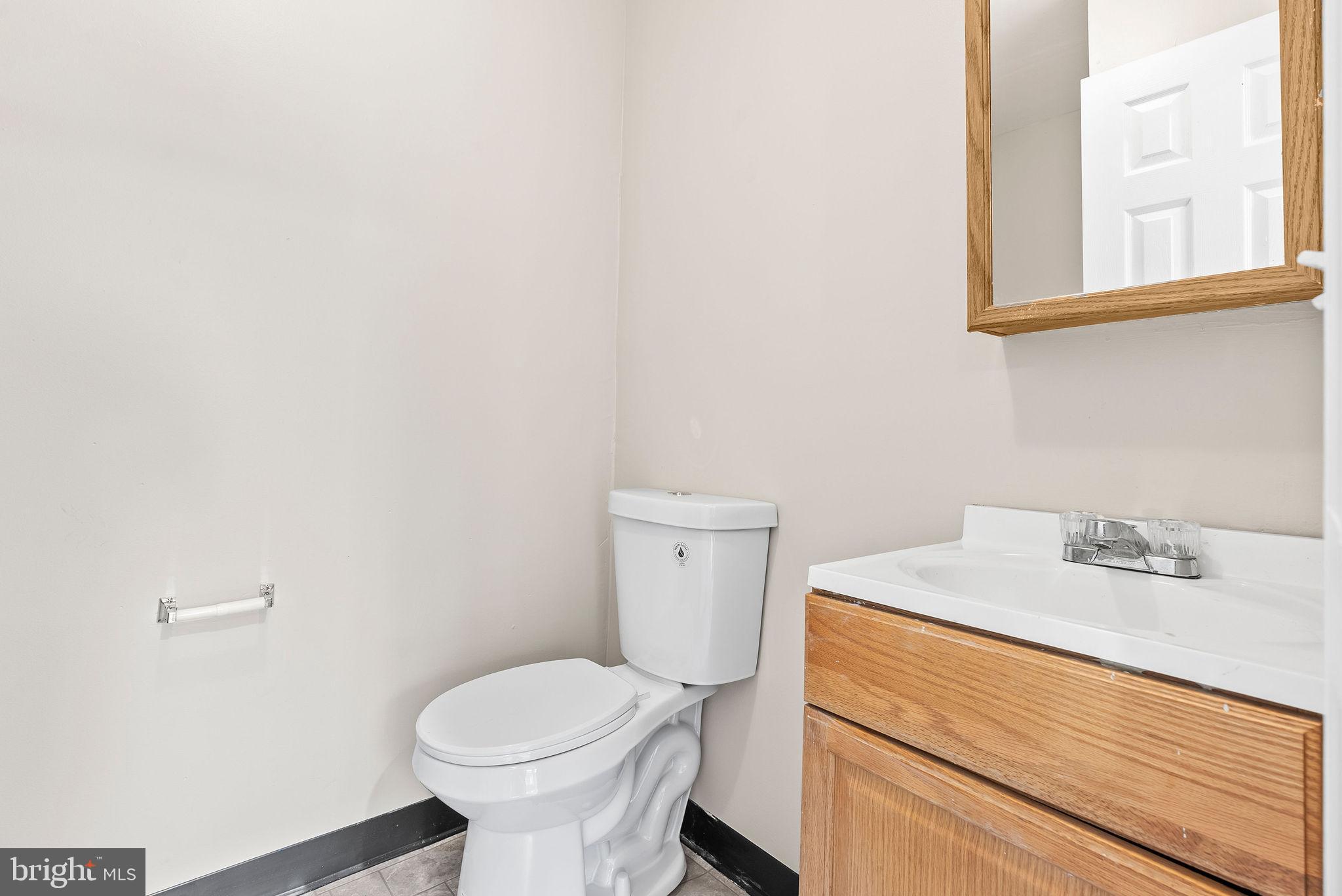 9711 Luguna Road Baltimore, MD 21220 - Photo 6 of 37 a bathroom with a sink a toilet and a mirror