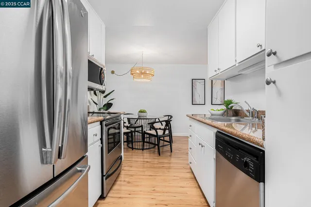a kitchen with granite countertop a table chairs sink and cabinets