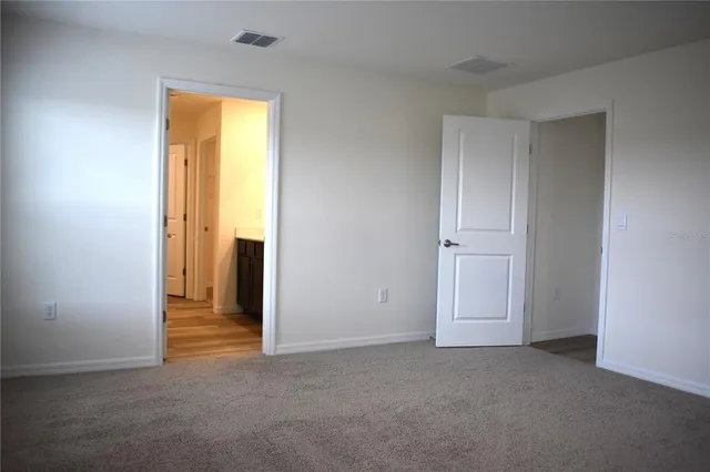 an empty room with window and closet area