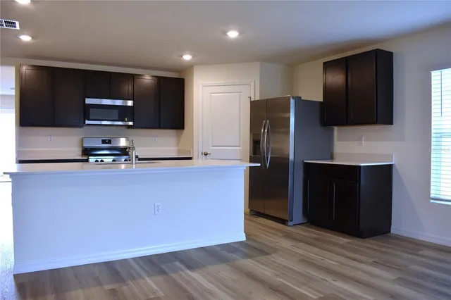 a kitchen with stainless steel appliances granite countertop a refrigerator and a microwave