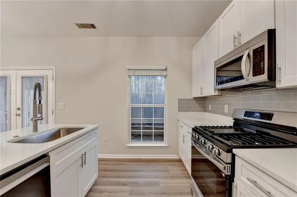 a kitchen with stainless steel appliances a stove cabinets and a sink