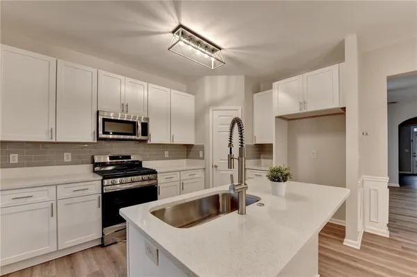 a kitchen with white cabinets and stainless steel appliances