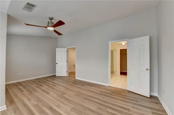 a view of a room with wooden floor and a ceiling fan