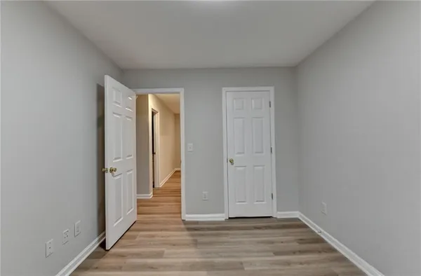 a view of a hallway with wooden floor and closet
