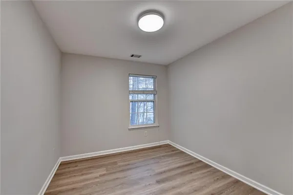 an empty room with wooden floor and a window