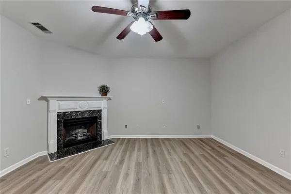 an empty room with a fireplace and fan