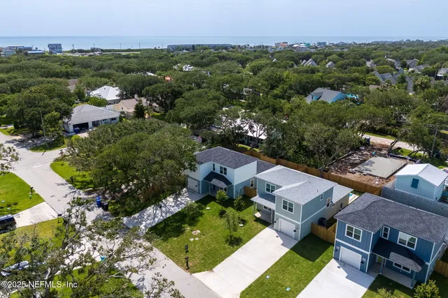 an aerial view of multiple houses with yard
