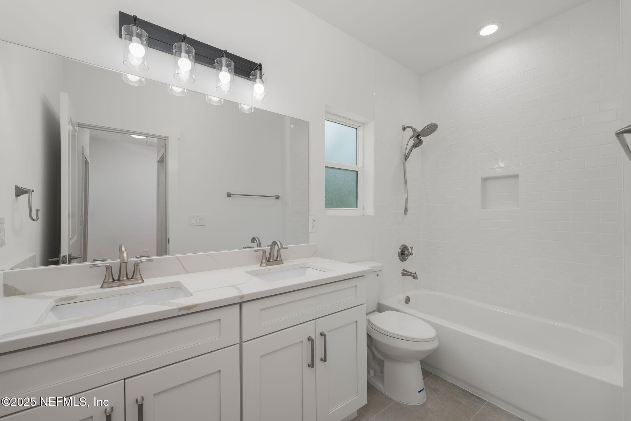 603 Twenty Second Street St. Augustine, FL 32084 - Photo 26 of 36 a bathroom with a toilet a sink a mirror a bathtub and vanity