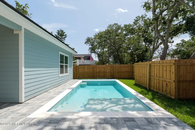 a view of backyard with wooden fence