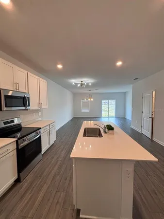 a kitchen with a sink a stove and cabinets