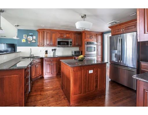 21 Lawrence Lane Lexington, MA 02421 - Photo 5 of 18 a kitchen with stainless steel appliances granite countertop a refrigerator a sink dishwasher a stove and a dining table with wooden floor