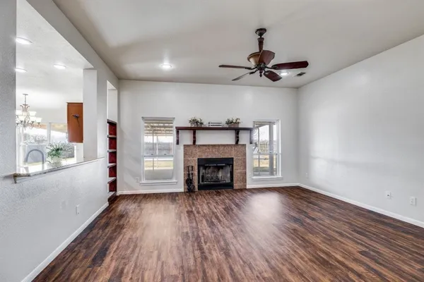 a view of an empty room with a fireplace and a window