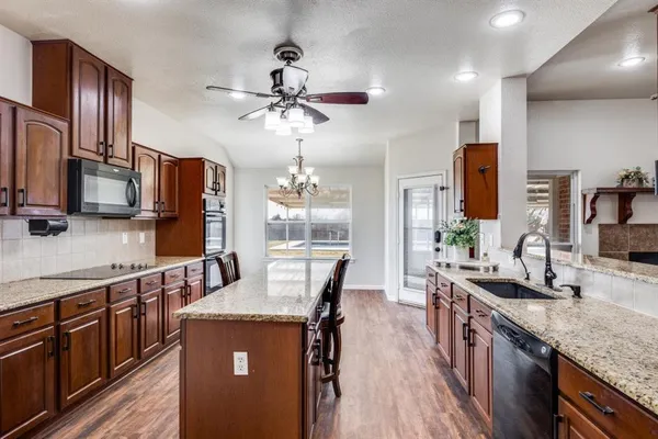 a kitchen with stainless steel appliances granite countertop a sink a stove and refrigerator
