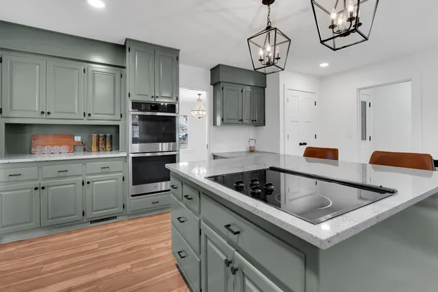 a kitchen with stainless steel appliances granite countertop a sink and a refrigerator