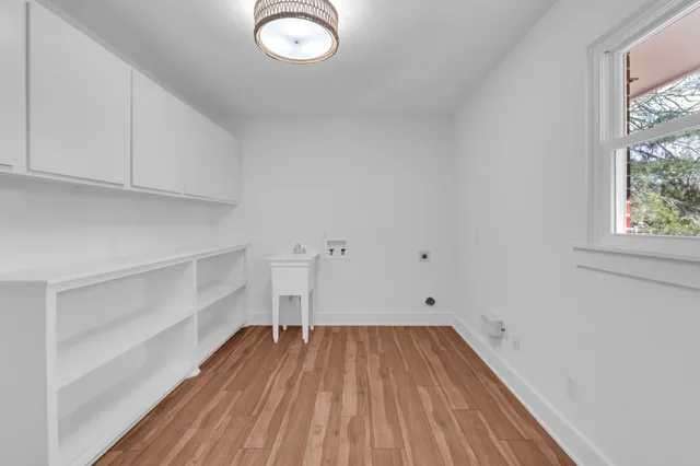 a view of a room with wooden floor and a ceiling fan