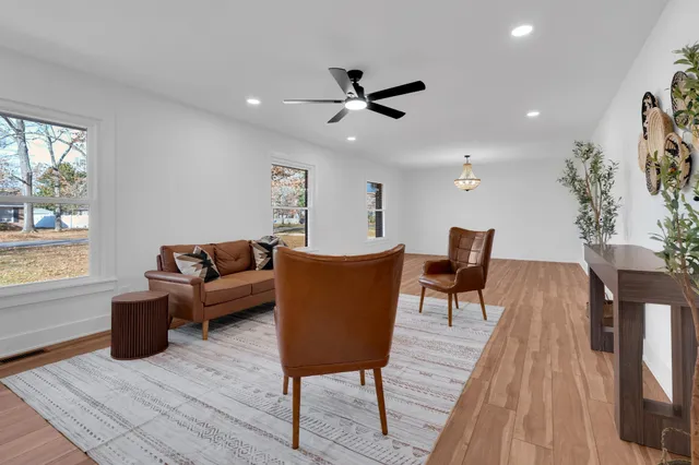 a living room with furniture a window and a potted plant