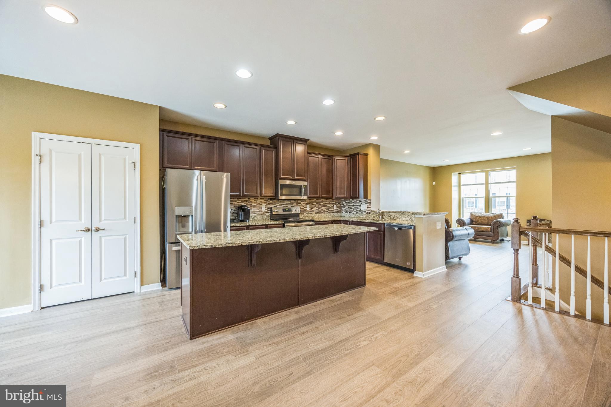 1072 Prime Place Sewell, NJ 08080 - Photo 12 of 36 a kitchen with stainless steel appliances granite countertop a refrigerator a sink dishwasher a oven and a dining table with wooden floor