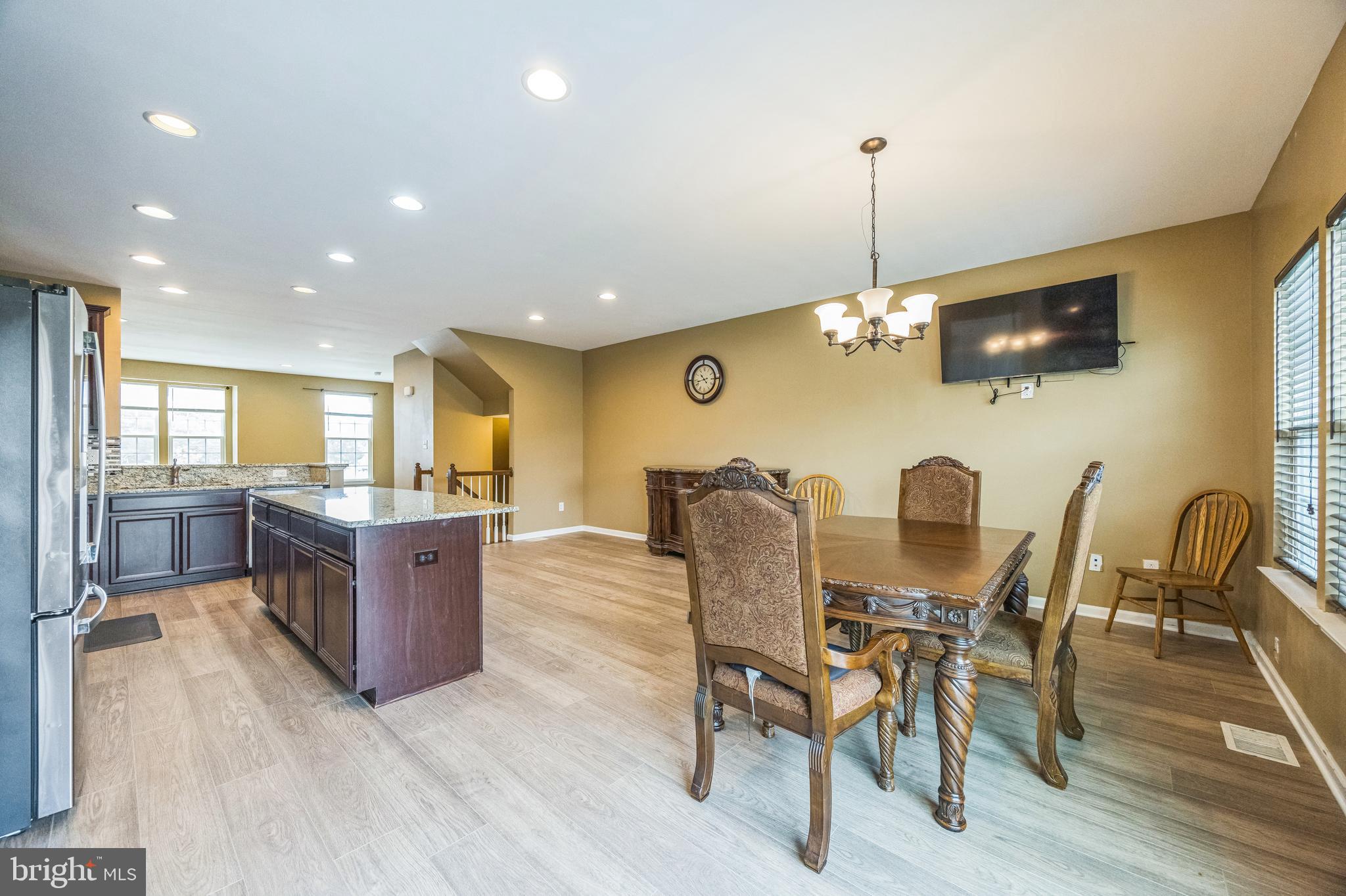 1072 Prime Place Sewell, NJ 08080 - Photo 14 of 36 a kitchen with stainless steel appliances kitchen island granite countertop a dining table chairs and a refrigerator